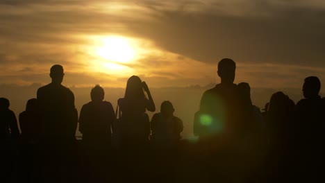 turistas viendo la puesta de sol sobre la