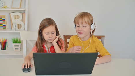 little boy and girl using a laptop and having an online class at home