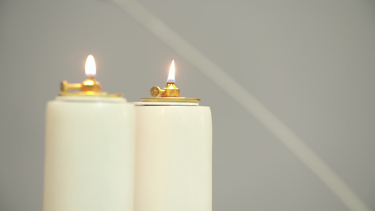 Due candele bianche accese con fiamme tremolanti