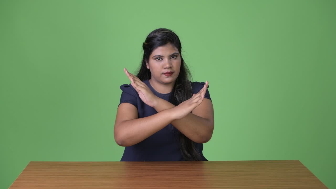 joven sobrepeso hermosa mujer de negocios india contra fondo verde