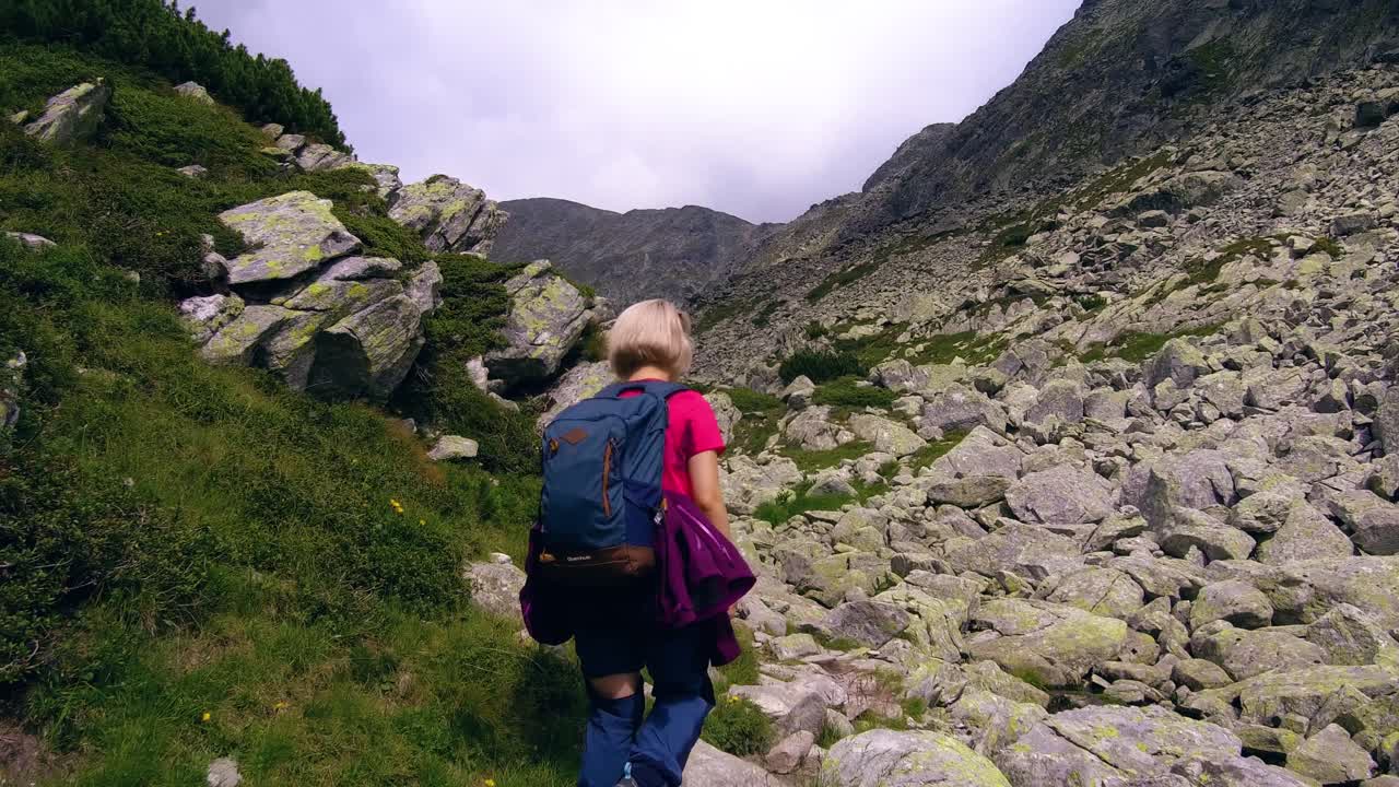 excursionistas caminando por la ladera de una montaña en la ladera rocosa de rumania