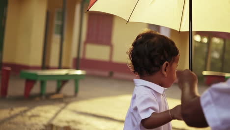 children walking under umbrella at school