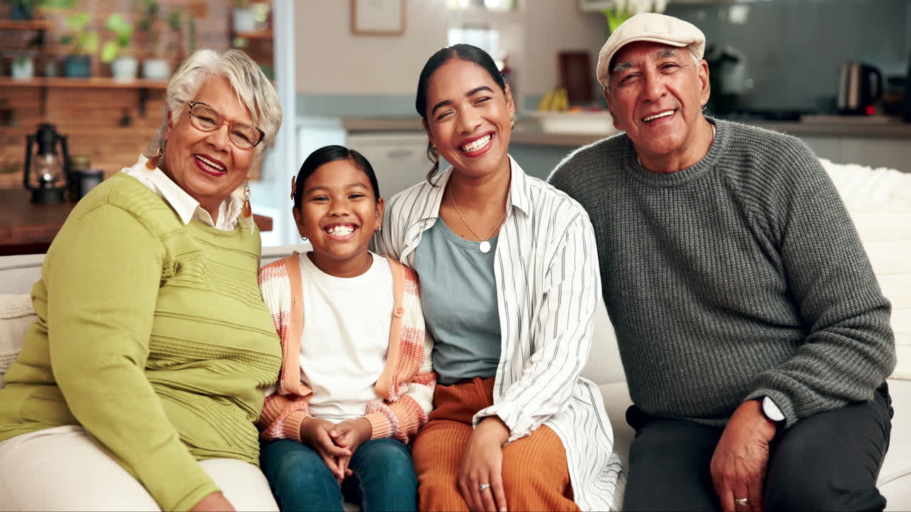 A multigenerational family is smiling and sitting on the couch