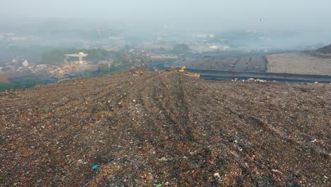 aerial view of a landfill with machinery and workers