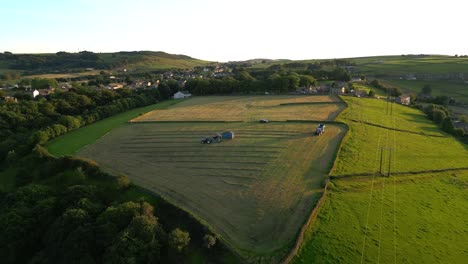 drone shot of farmers driving tractors in field