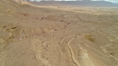 Aerial-footage-of-a-group-of-bicycle-riders-riding-on-bike-trails-in-the-desert-clifs