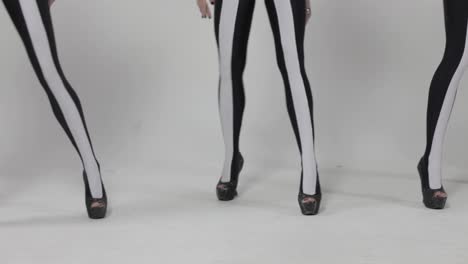 stylish women in striped tights dancing in high heels