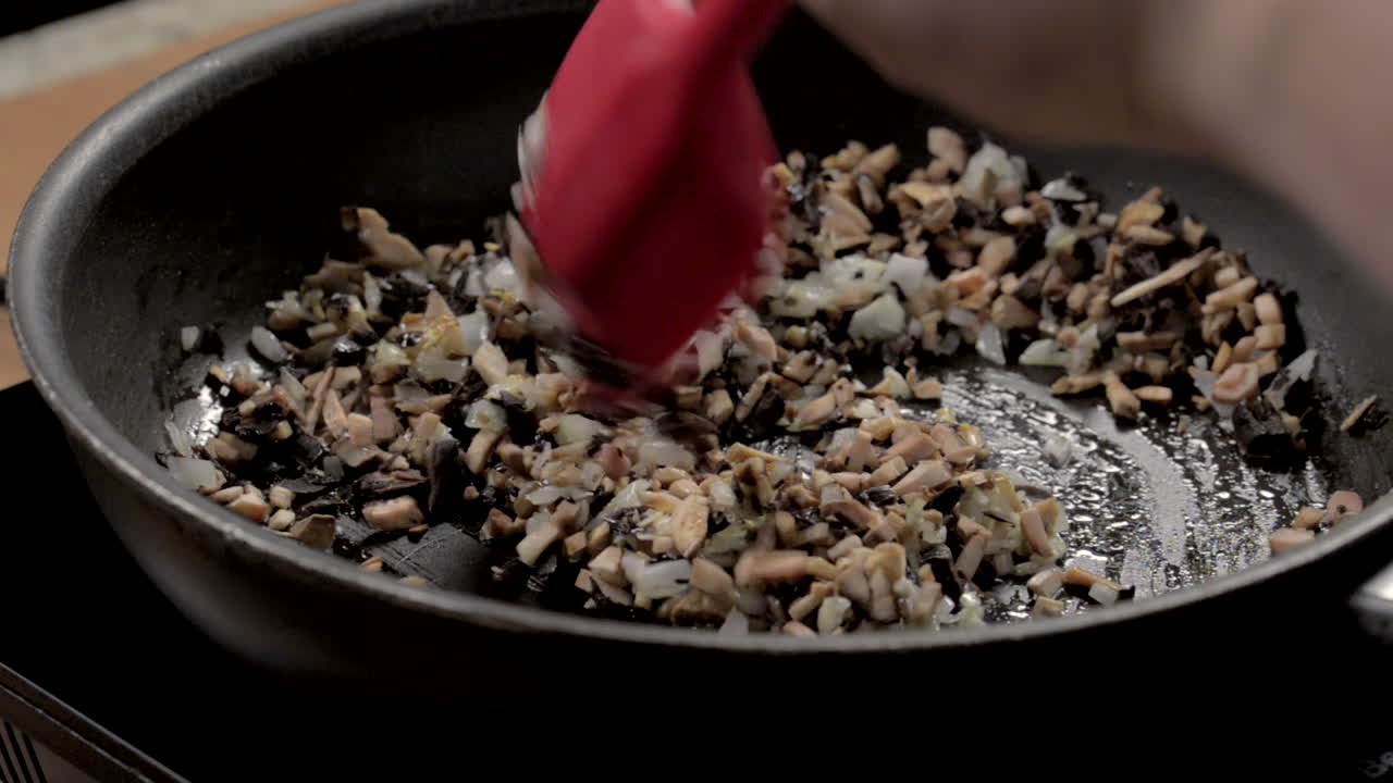 mezclar setas picadas sobre cebolla picada sobre aceite en una sartén caliente