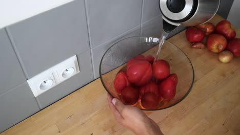 Geben-Sie-Wasser-Auf-Rote-Tomaten,-Die-Schön-In-Eine-Glasschüssel-Gelegt-Werden