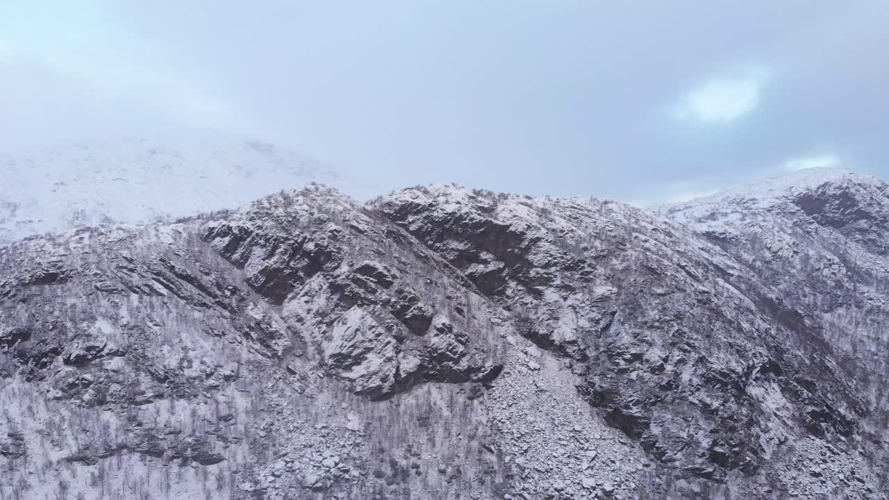 스칸디나비아 산맥의 긴 바위 눈 덮인 능선 - 빠른 공중 와이드 샷