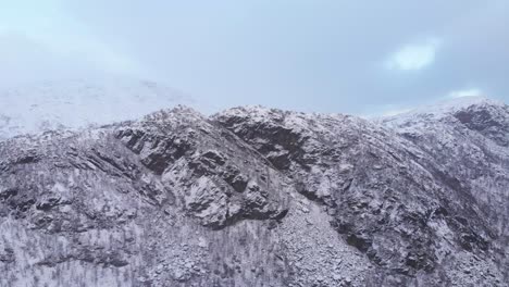 long rocky snowed ridge in the scandinavian mountain range - fast aerial wide shot