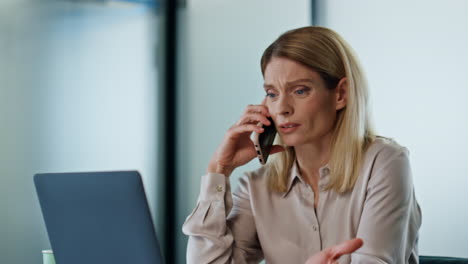 upset boss talking cellphone at office close up. sad woman loser fix problem