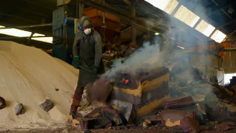 worker breaking hot mold in foundry workshop 4k