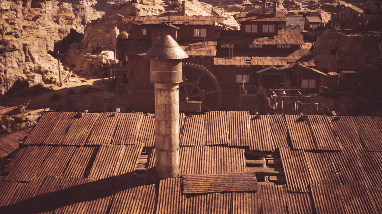 Abandoned mining town structures with weathered rooftops and a tower