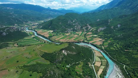 river vjosa with clear emerald water flowing to hills and mountains, peaceful rafting scenic spring landscape