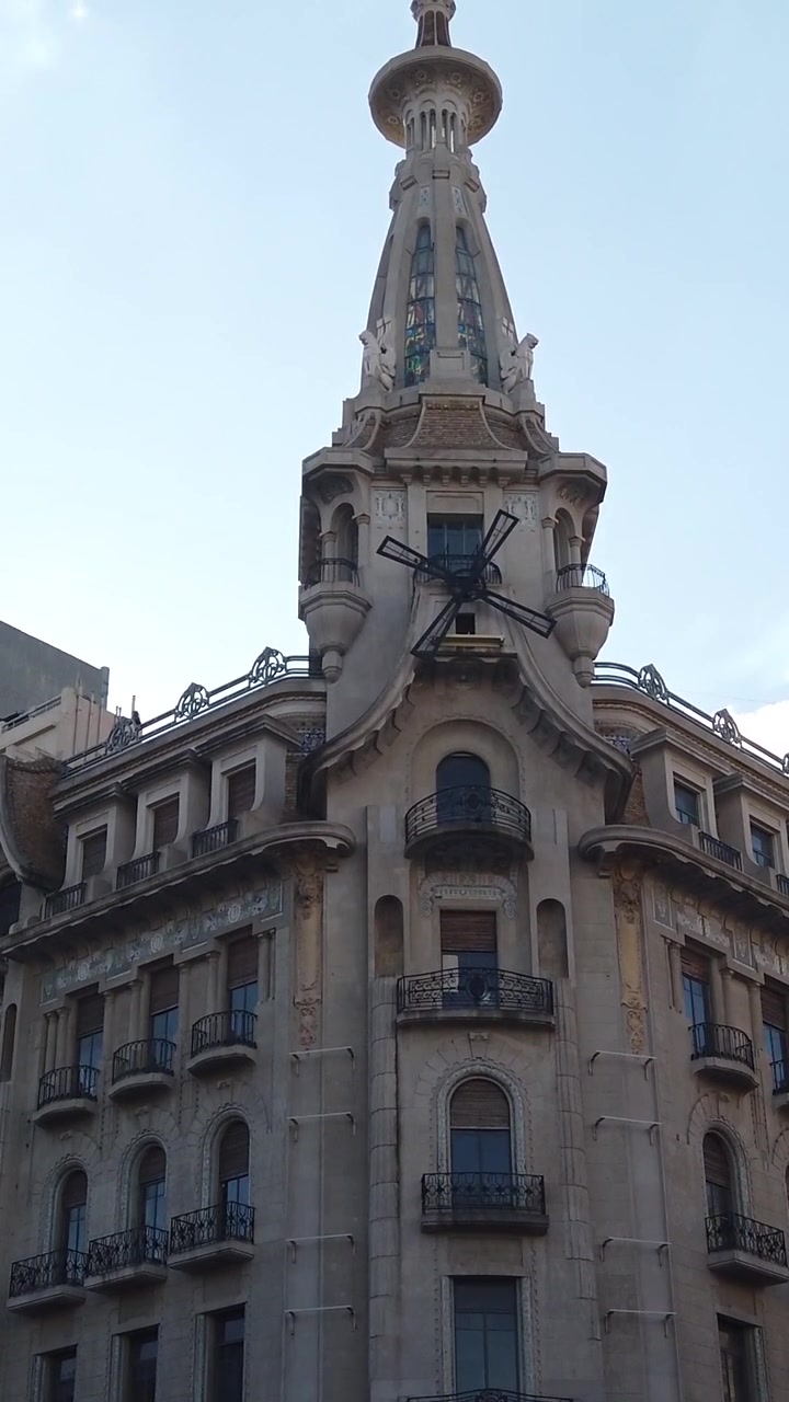 Cafetería Histórica El Molino, toma en ángulo bajo con inclinación ascendente, con fachada Art Nouveau y detalles de aspas de molino en Buenos Aires, Argentina.
