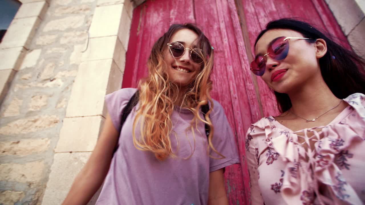 hermosas mujeres jóvenes lanzando confeti en las calles de la ciudad vieja