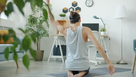 uomo che pratica yoga a casa