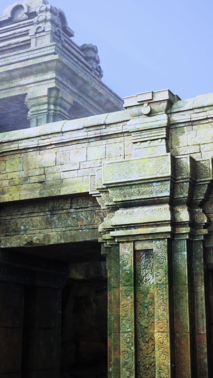 Ancient temple ruins by a serene lake surrounded by green hills