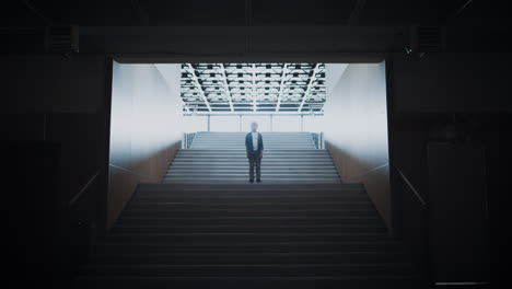 sad boy standing alone on school staircase. lonely guy posing at empty stairway