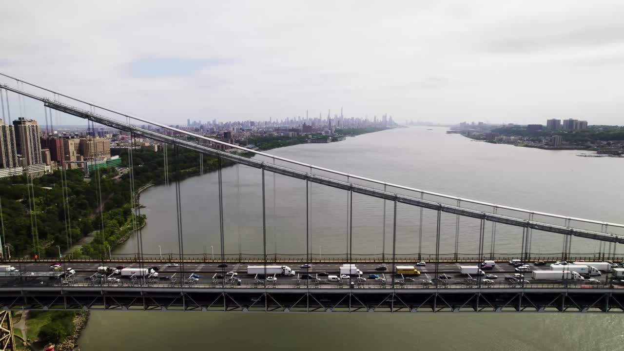 New York City skyline with traffic on George Washington Bridge in foreground, drone shot