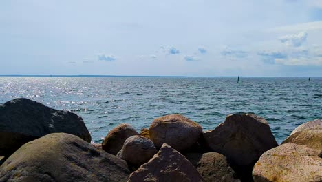 view to denmark from sweden over the sound and kattegat from swedish pier with big rocks