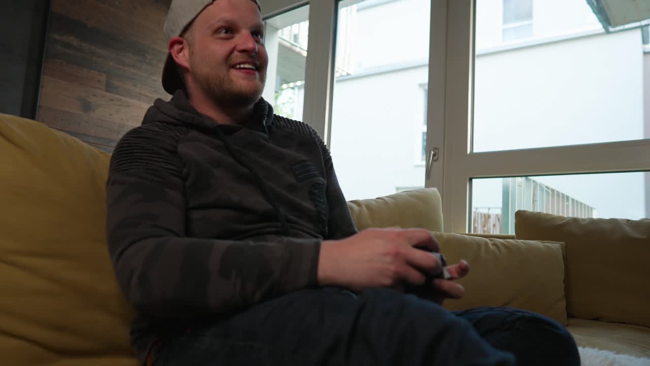 juegos - hombre milenario emocionado jugando un videojuego, tiro medio de ángulo bajo