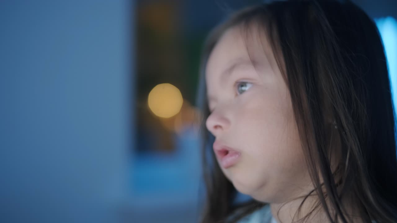 어린 소녀가 컴퓨터 앞에 앉아서 강한 감정을 표시합니다. 이 장면은 편안한 실내 환경에서 펼쳐지는 매력적인 순간 동안 그녀의 표현적 반응을 포착합니다.