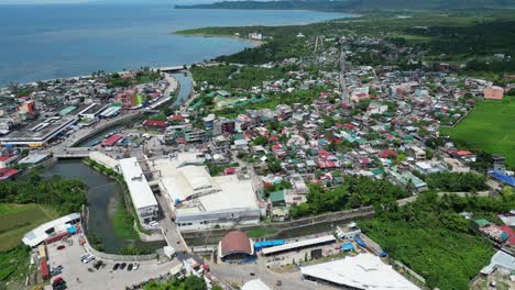 aerial establishing drone shot of urbanized coastal town facing idyllic blue ocean