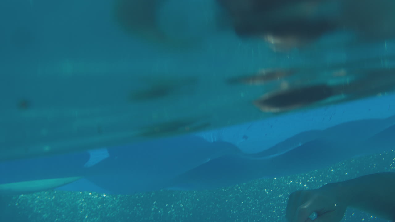 여름 휴가 동안 수영장에서 공기 침대에 떠다니는 여성을 는 남자의 수중 풍경