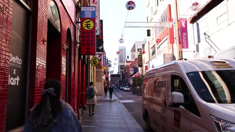 pedestrians and vehicles in bustling chinatown street