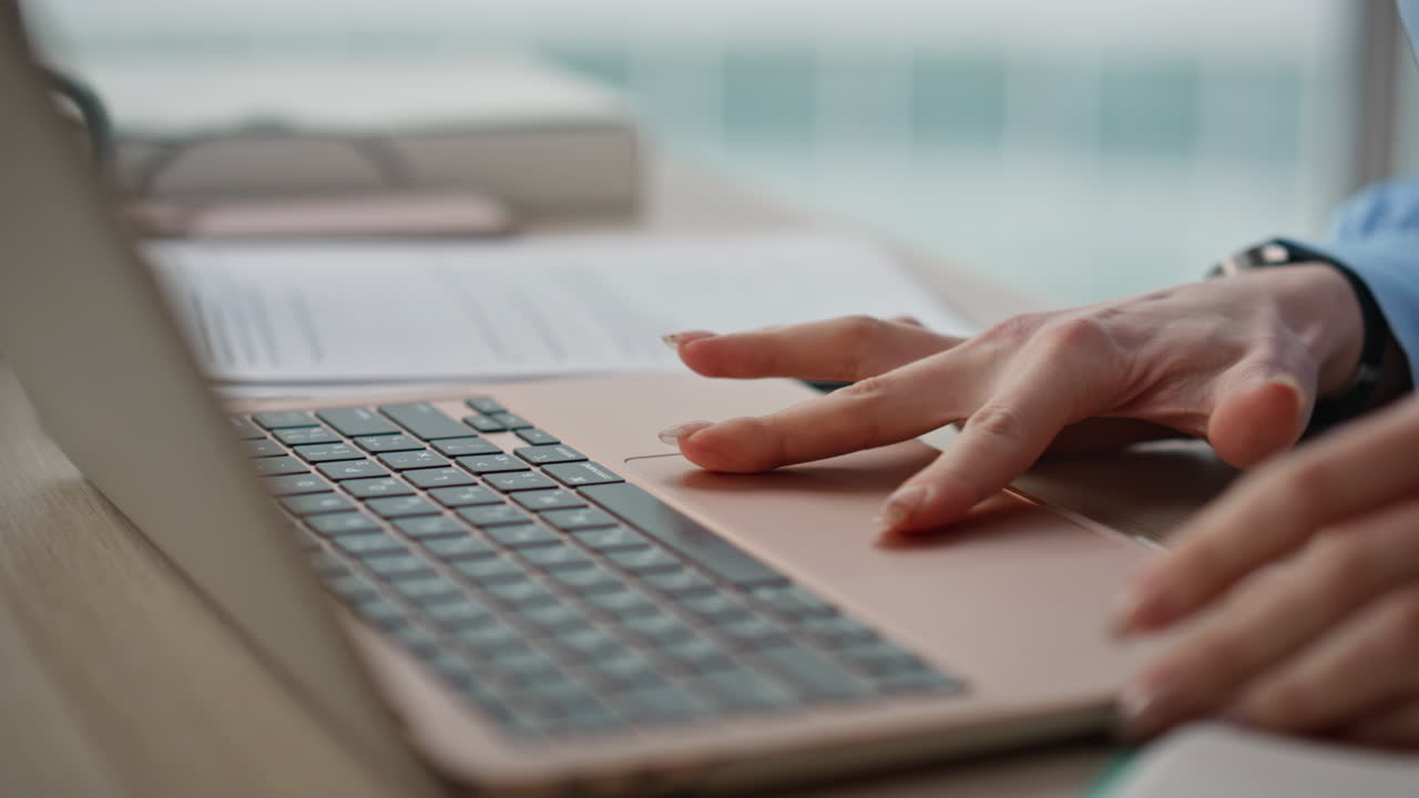 Lady fingers using touchpad laptop in office workspace closeup. Woman hands