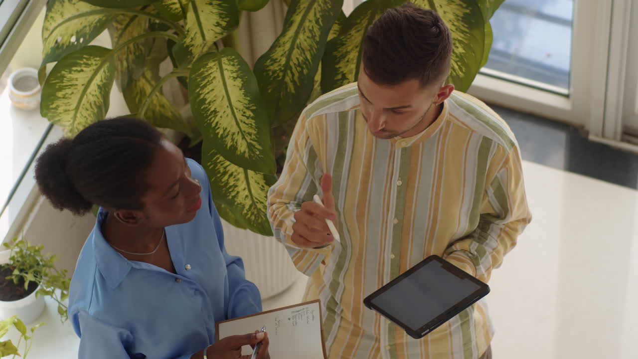 Chief Manager Giving Instructions to Female Employee High Angle