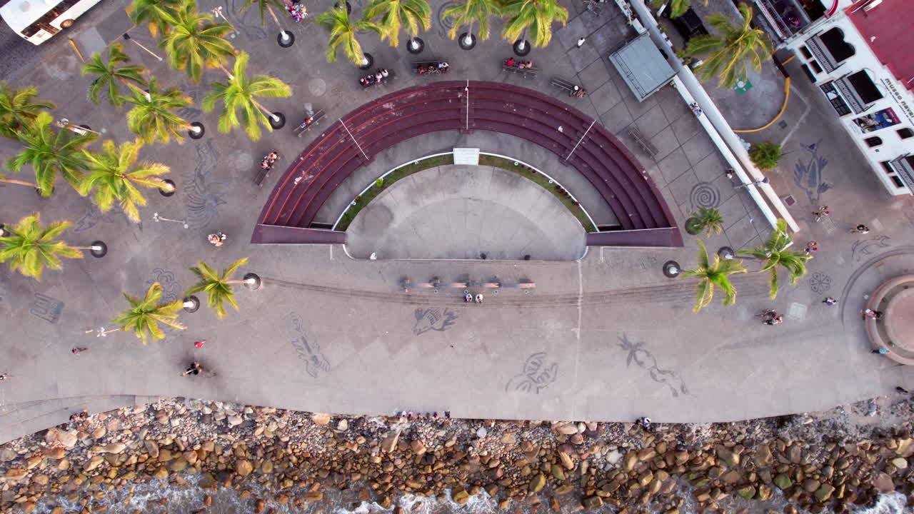 video aéreo con una vista cenital del paseo marítimo en los arcos de puerto vallarta, capturando también el teatro al aire libre junto al mar
