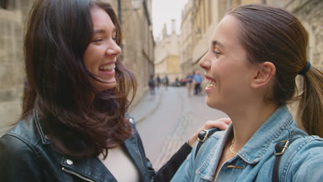 fotografía de una pareja de mujeres del mismo sexo posando para una selfie mientras visitan oxford, reino unido