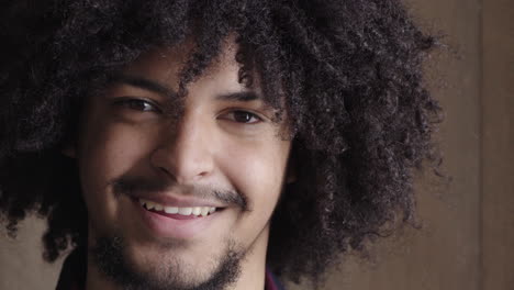 Primer-Plano-Retrato-De-Un-Joven-Apuesto-Sonriendo-Feliz-Mirando-A-La-Cámara-Exitoso-Estudiante-Masculino-Con-Moderno-Peinado-Afro