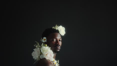 young black male model adorned with flowers posing at camera