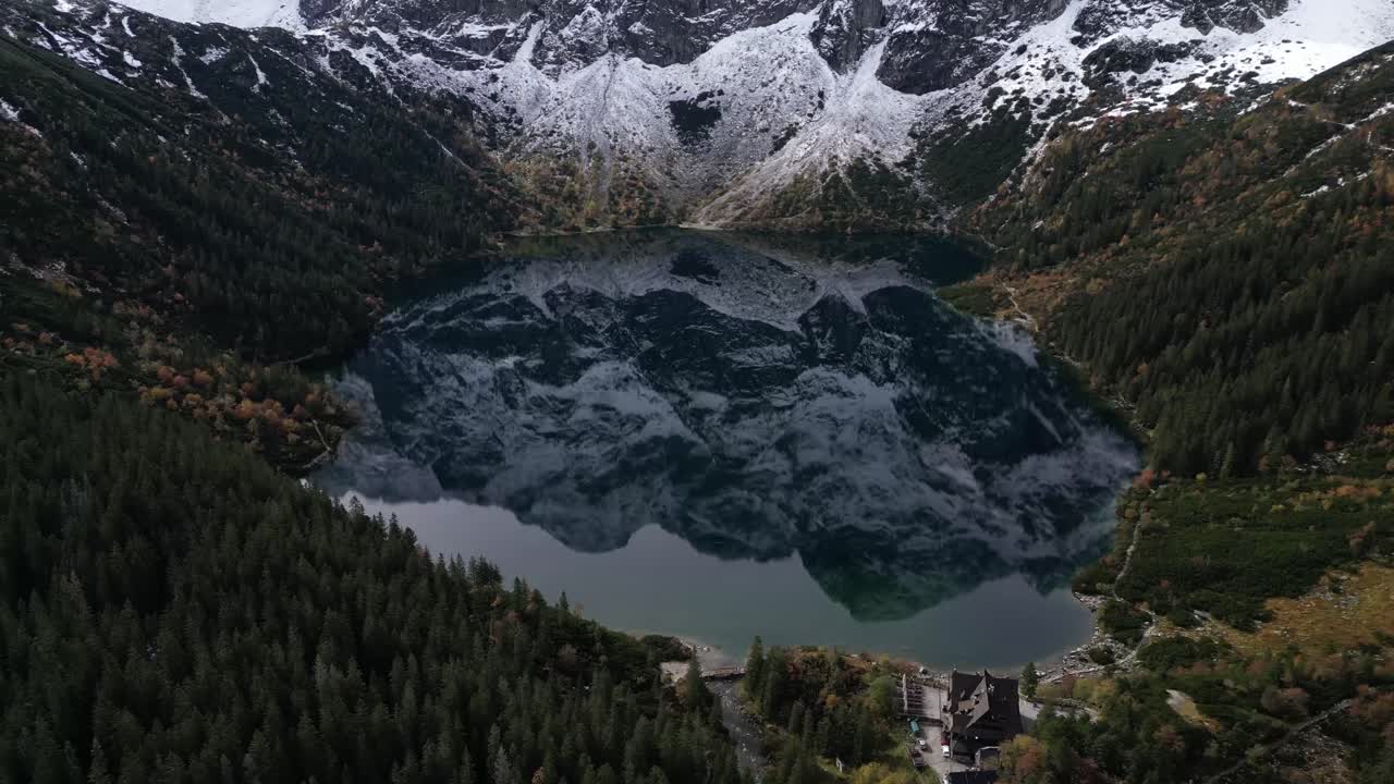 Aerial footage of snowcapped peaks reflected in Morskie Oko Lake in Zakopane Poland