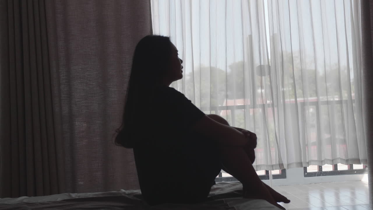 Sad And Depressed Women Sitting On Bed