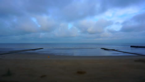 time lapse: sea view with some people walking on the beach and clouds passing by with miniature effect