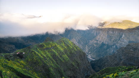 4K-Timelapse-from-above-as-clouds-move-over-small-house-in-mountains,-Madeira