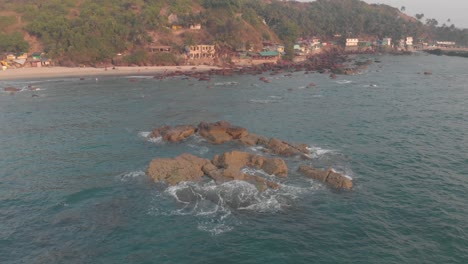 aerial view of a tropical beach with rocks and buildings