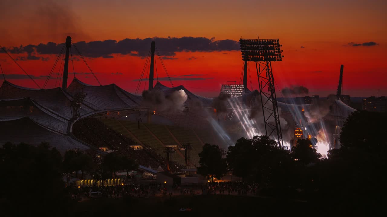 램스타인  ⁇  린데만 독일 메탈 밴드 콘서트 쇼 피로테크닉, 불, 연기, 불꽃과 빛과 함께 유명한 독일 ?? 헨 올림픽 스타디움에서 저녁 해가 지는 하늘과 엄청난 팬들의 군중