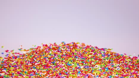 vibrant sprinkles cascade onto a growing pile