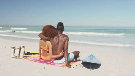 african american couple cuddling seaside