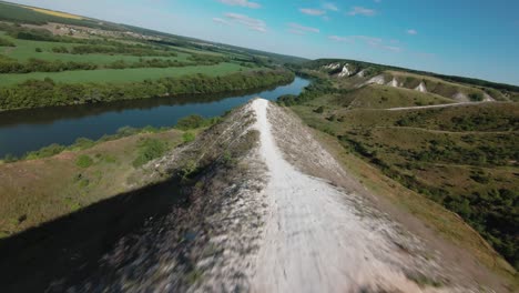 aerial view of a river valley with hills and a white path