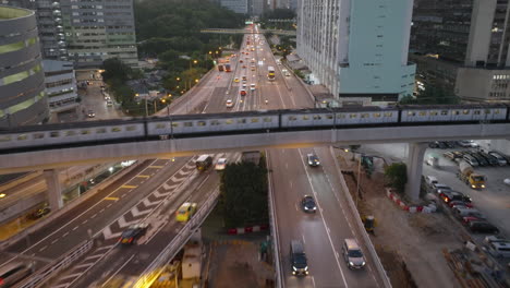 aerial backwards shot - traffic on road and train passing on bridge