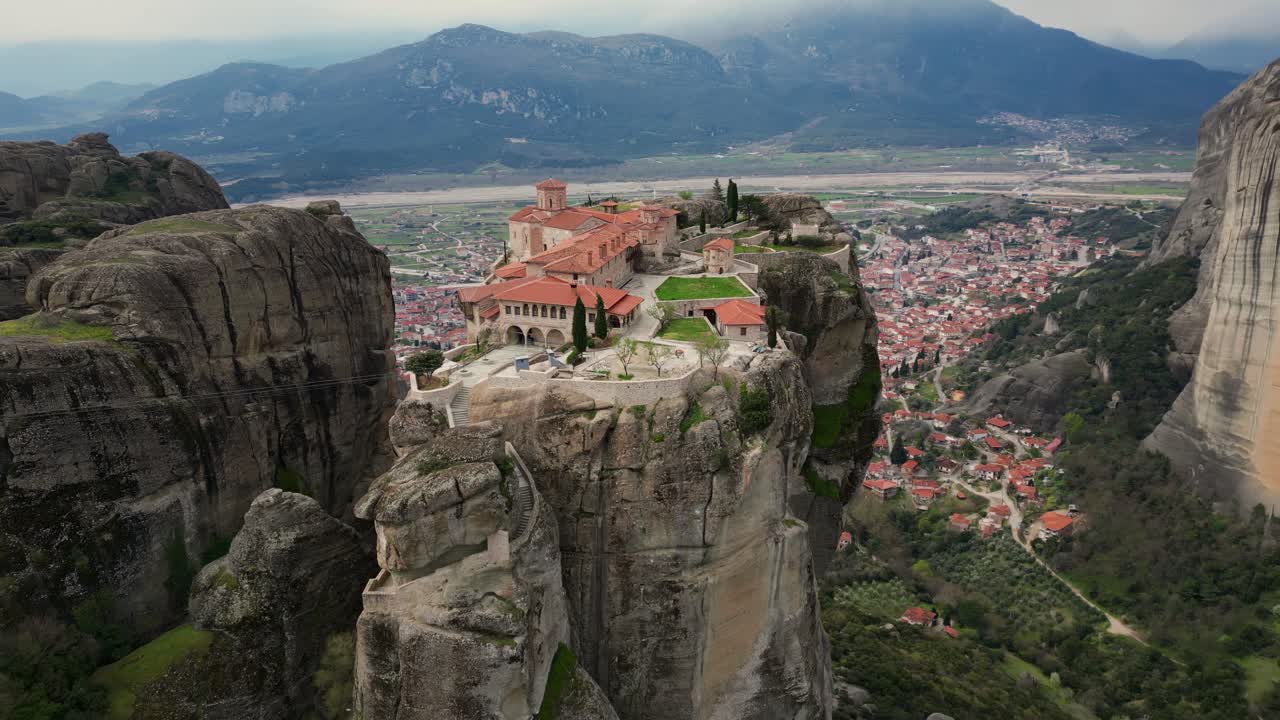Aerial of Meteora’s cliffside monastery perched high on rocky pillar, dramatic natural setting