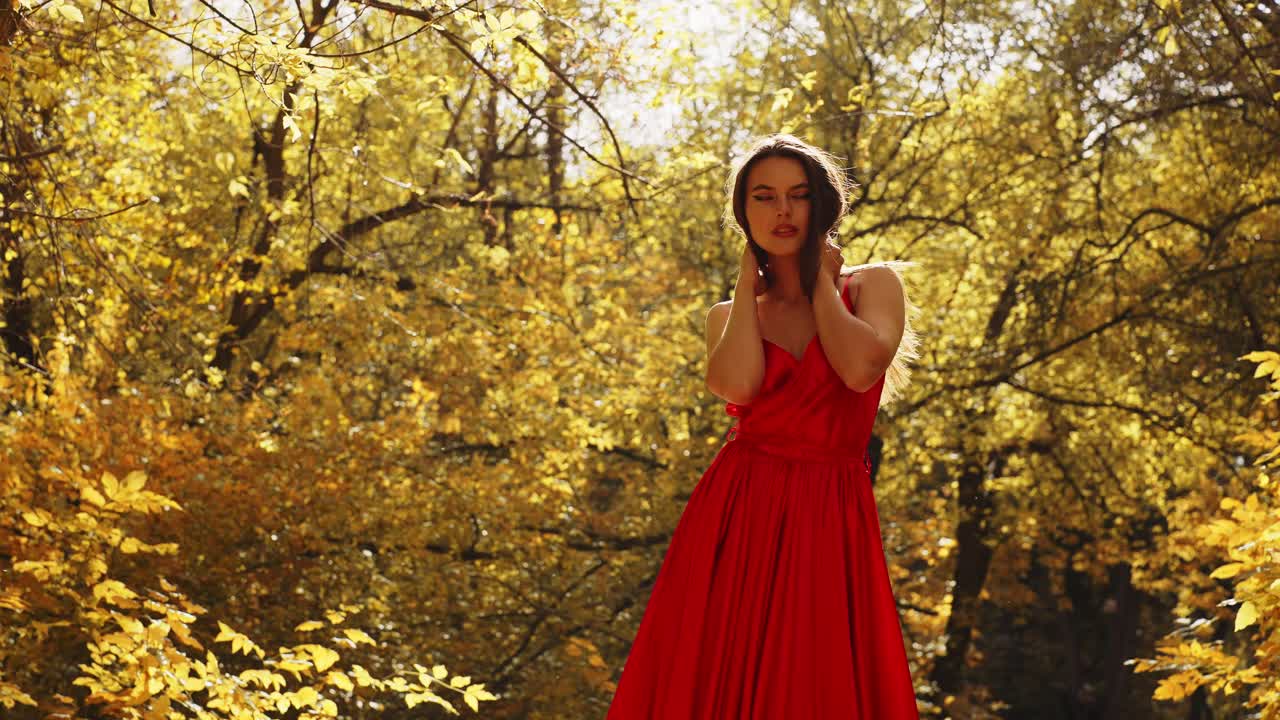 A Graceful Portrait of a Woman in a Flowing Red Dress Amidst Vibrant Autumn Foliage Capturing the Essence of Seasonal Beauty and Elegance
