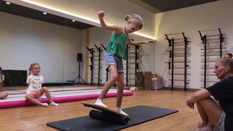 child balancing on balance board in gym